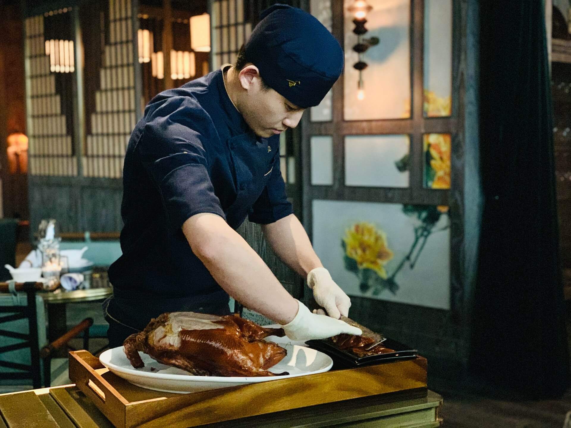 Chef carving a prepared duck.